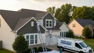 Professional house painters working on residential exterior in Olathe KS by paintingolatheks.com